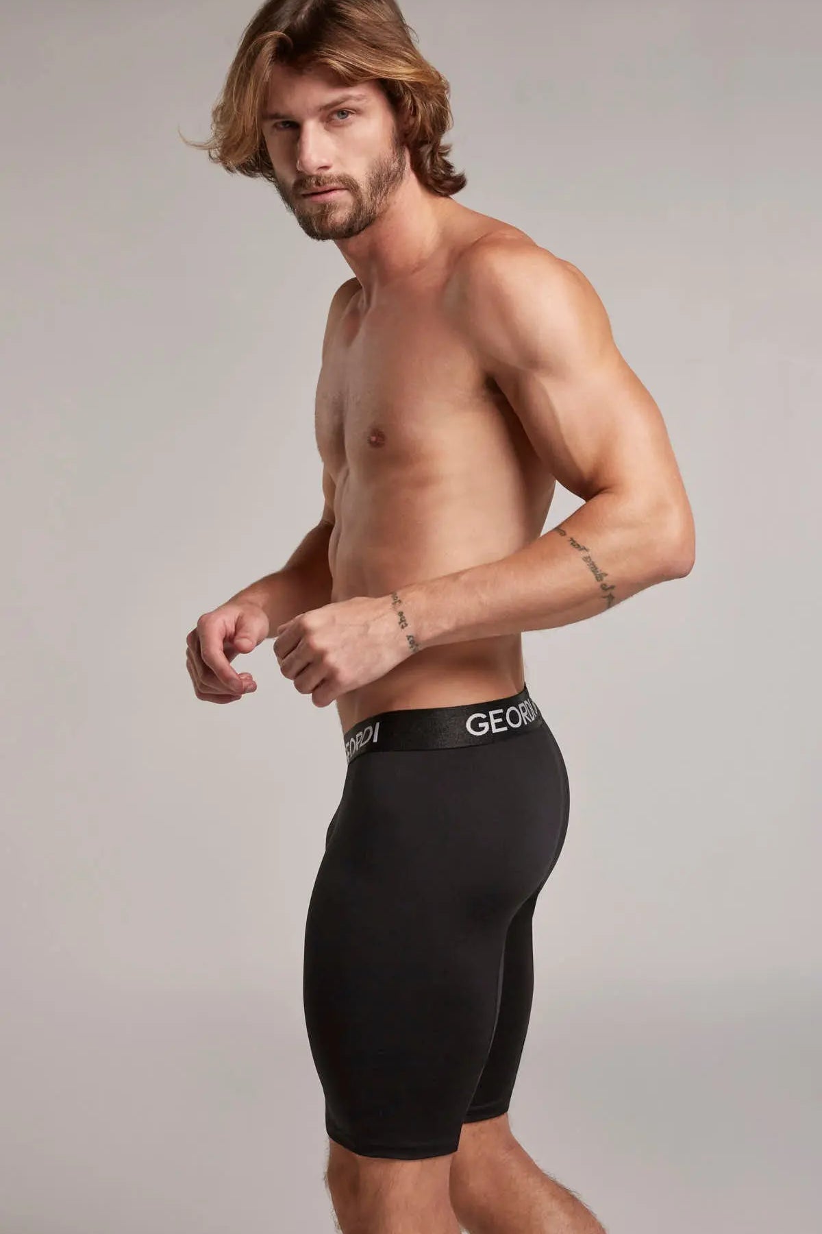 Hombre usando bóxer extra largo hasta la rodilla color negro de lado