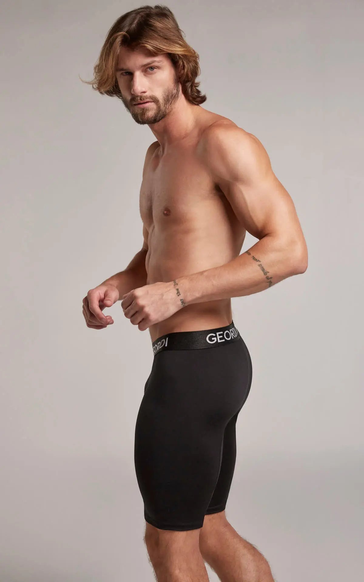 Hombre usando bóxer extra largo hasta la rodilla color negro de lado