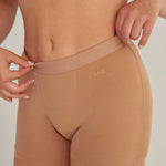 Panty cómodo con elástico ancho en cintura, color cafe, plano detalle, modelo de cabello rubio.