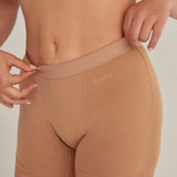 Panty cómodo con elástico ancho en cintura, color cafe, plano detalle, modelo de cabello rubio.