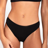Ropa interior tipo tanga con diseño anatómico – Diane & Geordi, color negro plano de frente cercano