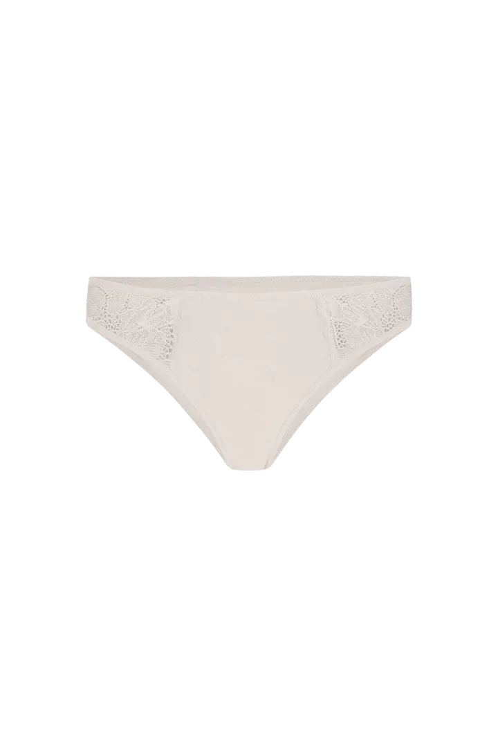 Panty tanga unicolor con laterales en encaje Diane & Geordi, color piel de lado fondo transparente 