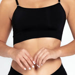 Vista frontal del top con tiras finas y diseño minimalista, color negro