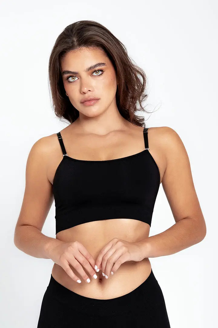 Vista frontal del top con tiras finas y diseño minimalista, color negro