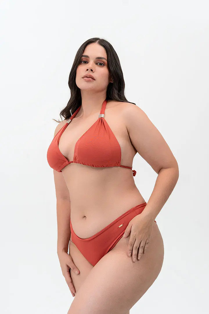 Modelo usando vestido de baño 2 piezas Diane & Geordi con panty tipo brasilera y recogido levanta cola, color arcilla de lado