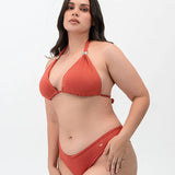 Modelo usando vestido de baño 2 piezas Diane & Geordi con panty tipo brasilera y recogido levanta cola, color arcilla de lado