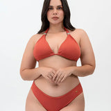 Modelo usando vestido de baño 2 piezas Diane & Geordi con panty tipo brasilera y recogido levanta cola, color arcilla